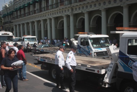 Habitantes de Soledad Atzompa que bloqueaban la Av. Enríquez frente al Palacio de Gobierno, con sus vehículos fueron desalojados con el uso de grúas y policías antimotines, quienes resguardaron el edificio. 