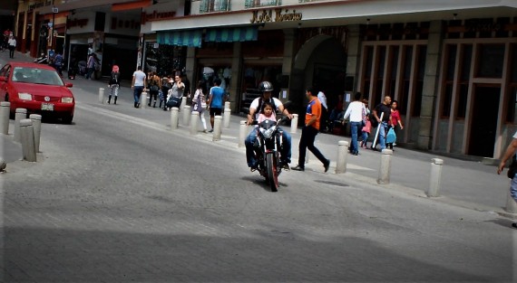 Caballero en moto con casco. Niña, bebé en moto sin casco. Si no importa la seguridad de la pequeña, menos importa estar cometiendo una falta al reglamento. 
