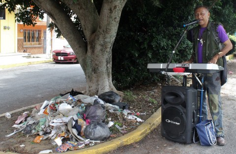 Amenizando el día el artista callejero que se nombra Apache Solitario, músico tecladista, con el paisaje de siempre en Xalapa, los montones o montoncitos de basura afeando el panorama. 