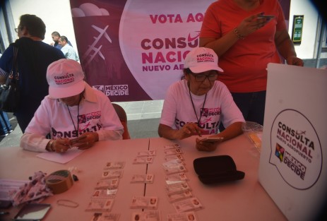 Con algunas fallas en la aplicación del teléfono, uno a uno los ciudadanos emiten su voto mientras una de las funcionarias apunta en una libretita endemientras.  