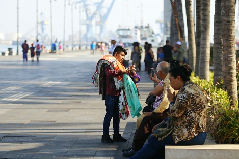 Turistas disfrutan de un día soleado en el paseo del malecón. Vendedores, entre ellos menores de edad, y sacamonedas, los abordan para obtener alguna ganancia de la derrama económica que dejan a su paso.