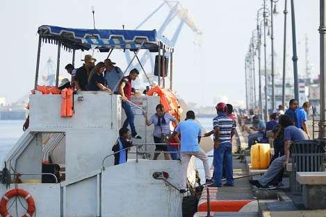 Turistas disfrutan de un día soleado en el paseo del malecón. Vendedores, entre ellos menores de edad, y sacamonedas, los abordan para obtener alguna ganancia de la derrama económica que dejan a su paso.