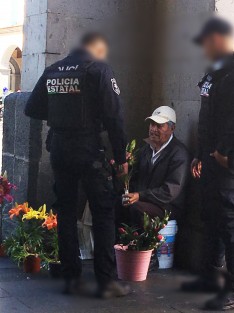 Oficial compra flores para su pareja en los bajos del Palacio de Gobierno.