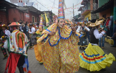 Con trajes multicolores sus danzantes acompañan al santo por la larga alfombra de aserrín hasta iglesia de la Asunción.  