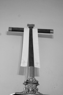 <em>Este es el símbolo de la Vera Cruz, y lábaro de la evangelización iniciada por los 12 primeros apóstoles franciscanos que propagaron la fe en N.S. Jesucristo en México, está hecha con mástiles de las naves de Hernán Cortés y proviene del Antiguo Convento Franciscano en Xalapa (1534)</em>.
