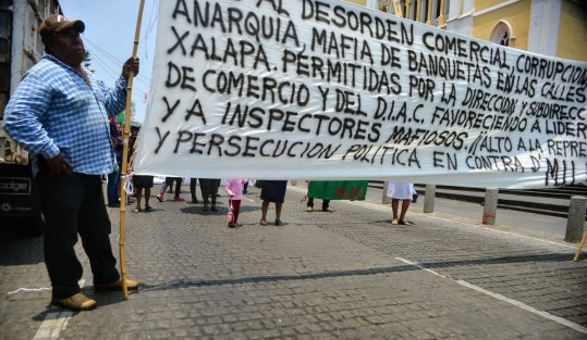 Integrantes de  la agrupación MILES bloquearon  la calle Enríquez; la razón, la misma de siempre, espacios para poder vender sus productos en la calle; incluso amenazaron con permanecer ahí hasta el desfile de mañana.  