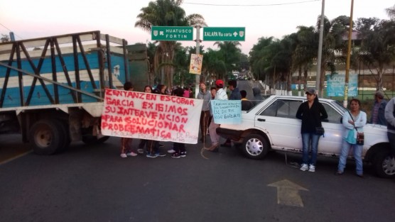 Padres de familia cuyos hijos estudian de la escuela Secundaria Técnica Agropecuaria número 125 de la cabecera municipal de Comapa, bloquearon el tramo carretero de Huatusco-Conejos a la altura de la entrada a este municipio de Comapa, en protesta porque les pretenden quitar una parcela de 5 has. 