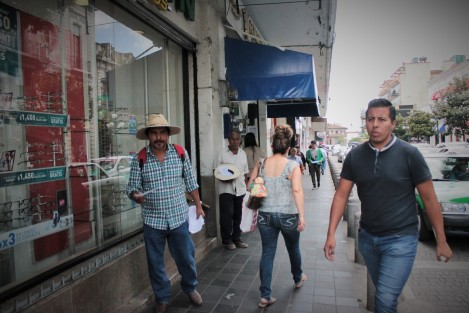 Algunos integrantes de los 400 Pueblos hacen un intento por entregar volantes y recibir alguna moneda, mientras los peatones los ignoran.