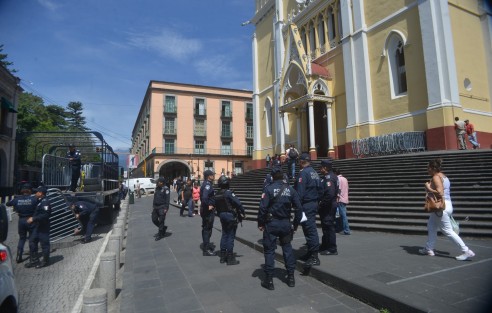 Elementos de Seguridad Pública bajan las vallas que serán colocadas el día de mañana duránte el entierro del Cardenal Sérgio  Obesoa