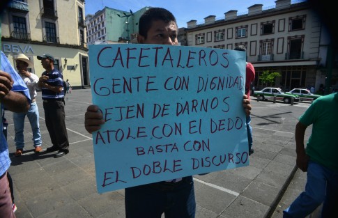 Miembros del Consejo de Café de Coatepec, con cartulinas en mano acusan que por una disputa entre la Secretaría del Bienestar contra la de Agricultura y Desarrollo Rural (SADER) paralizaron la asignación de recursos a productores de café.  