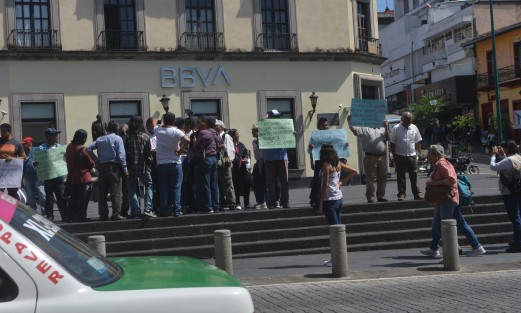 Miembros del Consejo de Café de Coatepec, con cartulinas en mano acusan que por una disputa entre la Secretaría del Bienestar contra la de Agricultura y Desarrollo Rural (SADER) paralizaron la asignación de recursos a productores de café.  