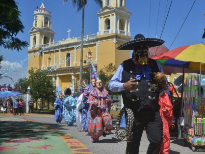 Miles de personas locales y visitantes disfrutan de las danzas y de los coloridos trajes  durante el recorrido del arco por la calle principal del municipio. 