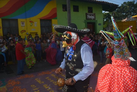 Miles de personas locales y visitantes disfrutan de las danzas y de los coloridos trajes  durante el recorrido del arco por la calle principal del municipio. 