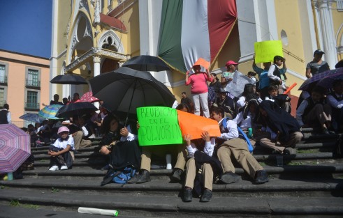 Maestros,  padres  de familia y alumnos de las escuela Telesecundaria Carolino Anaya y María del Carmen Serdán, se manifestaron y bloquearon por algunos minutos la calle de Enríquez, para exigir al Gobierno del Estado y a la SEV, la reubicación del plantel y escrituración de la misma.