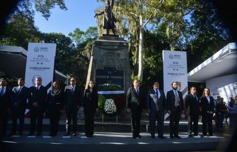 Rodeada de mucha seguridad, una ola de reporteros y fotógrafos, la encargada de despacho de la Fiscalía General del Estado, Verónica Hernández Giadáns, y sus colaboradores, montaron guardia de honor y colocaron una ofrenda floral ante el monumento a Miguel Hidalgo.