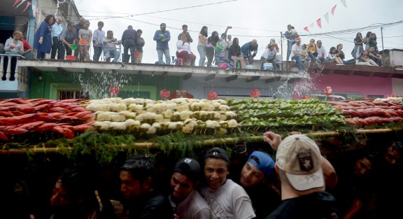 Durante el recorrido de los arcos por las calles de Coatepec, las personas mojan desde sus azoteas los arcos y a las personas que los cargan.  