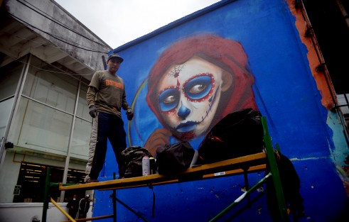 Jovenes grafiteros pintan paredes con motivos de Día de Muertos para que los visitantes puedan apreciar una parte del arte de esta ciudad. 
