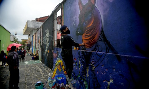 Jovenes grafiteros pintan paredes con motivos de Día de Muertos para que los visitantes puedan apreciar una parte del arte de esta ciudad. 