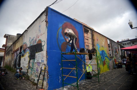 Jóvenes grafiteros pintan paredes con motivos de Día de Muertos para que los visitantes puedan apreciar una parte del arte de esta ciudad. 