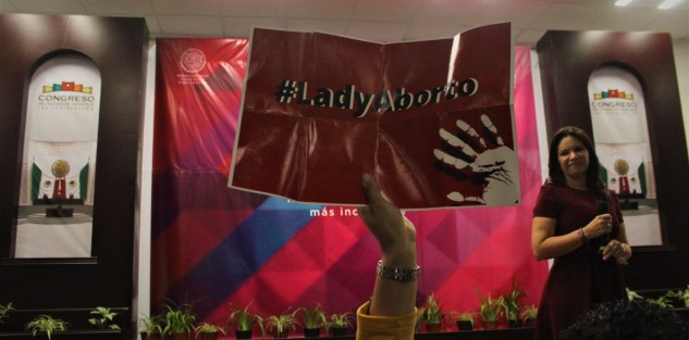 Manifestante confundida se llevó el cartel equivocado.  