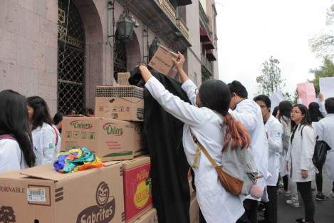 Con cajas, sus batas y libros, estudiantes de la Facultad de Medicina construyeron un altar para los jóvenes asesinados en el estado de Puebla, así como otros alumnos de la UV, que en diferentes fechas han sido víctimas de la violencia.  