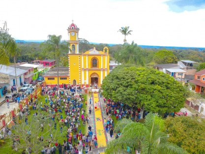 Con una bella alfombra tradicional de aserrín elaborada por niños, jóvenes y adultos de la Comunidad, fueron recibidos los caminantes con la flor que utilizarán para la elaboración del Arco Floral acompañados de la Madrina Mara Chama Villa. 