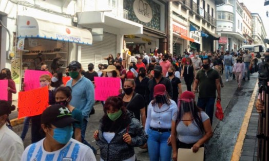 Después de casi 90 días de tener sus negocios cerrados, comerciantes del centro de la ciudad de Xalapa marcharon hacia Plaza Lerdo y por minutos cerraron la vialidad de la calle Enríquez, para exigir que los dejen trabajar pues les urge pagar rentas, servicios y sueldos de empleados, así como el sustento de sus familias. 