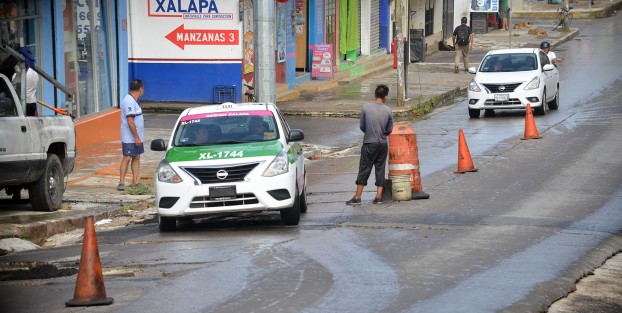 Un padre y sus hijos encontraron una oportunidad de poder llevar comida a  casa tapando algunos de los muchos baches de la avenida Ebano, tapando y pidiendo alguna cooperación para realizar su labor.  