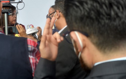 Miembro del staff que acompaña a la diputada local Rosalinda Galindo Silva  le hace señas para cortar la entrevista con medios locales cuando las preguntas <em>Le resultaron incomodas</em>.   