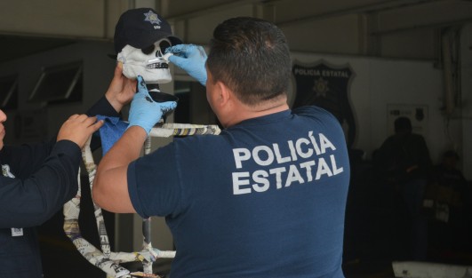 Personal de la SSP se prepara para los días de muertos  arreglando  un maniquí en el estacionamiento de esa dependencia.