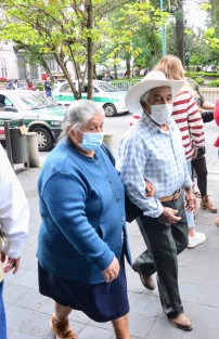 Sin las prestaciones del tamaño de las de diputados o senadores, una pareja de adultos mayores porta correctamente sus cubrebocas.  
