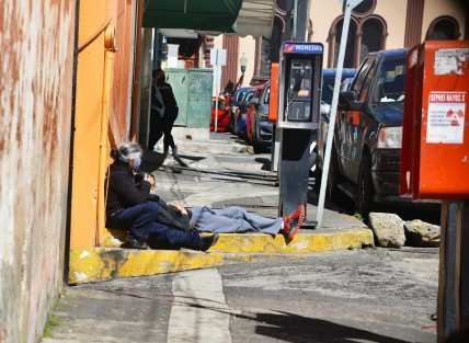 Mujer de la tercera edad junto a su familiar esperan  afuera del hospital F. Nachón.