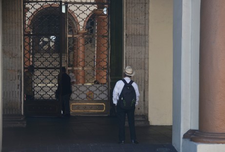 Una persona de la tercera edad con aspecto campesino observa el palacio de gobierno. 