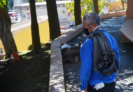 Un hombre de aspecto humilde aprecia una de las virtudes de la ciudad de Xalapa,  en este caso la que representa la justicia, eso sí, con su cubreboca bien puesto.