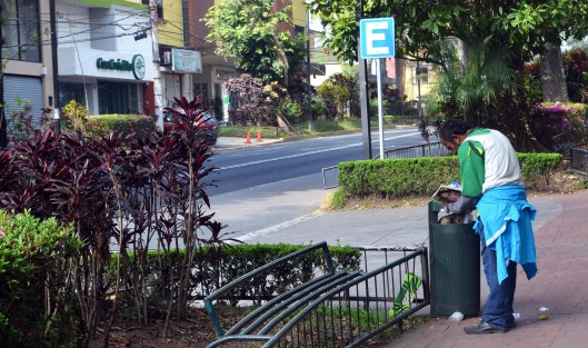 Un hombre en situación de calle busca algo de comida en un bote de basura de la avenida Ávila Camacho.