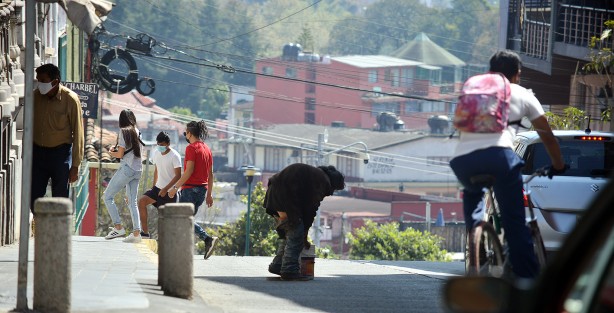 Un hombre que padece de alguna enfermedad física y mental y que vive en las calles de la ciudad, cruza la calle  para ponerse en un sitio donde no lo corran. 