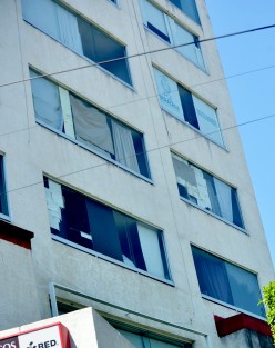 En las ventanas del edificio se puede ver cómo improvisan con cartones y papel cortaderos para que no les pegue el sol.