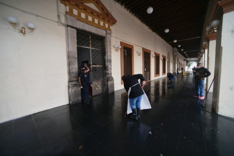 Trabajadores de gobierno limpian los pasillos y paredes del  Palacio después de las pintas realizadas durante la marcha del Día de la Mujer.  Algunos monumentos tendrán que esperar algunas semanas, como el a la madre.