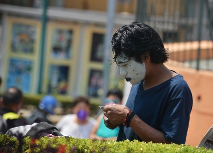 Un joven con la cara pintada se prepara para su jornada laboral en la avenida Ávila Camacho.