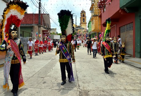Danzantes tradicionales de la región llegan para acompañar la procesión que recorre distintos altares colocados por todo el pueblo, y donde son recibidos por los <em>mayordomos</em> de cada lugar.