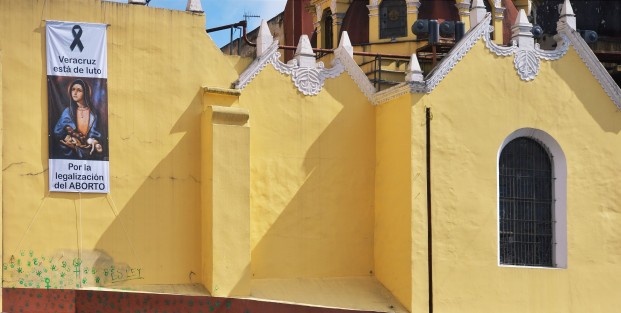 Tal como lo declaró el párroco de la Catedral de Xalapa, la fachada continúa mostrando las pintas que realizaran quienes festejaron la aprobación de la reforma de la ILE por el Congreso. En tanto, con una manta hacen sentir su opinión sobre el tema.  