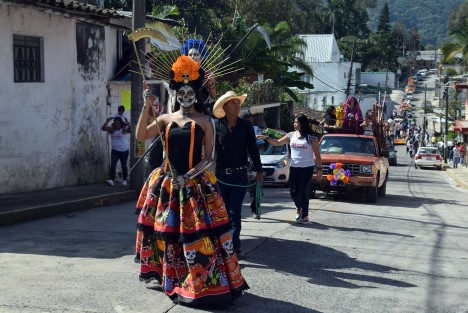 Jovencitas caracterizadas de la  santa muerte, automóviles adornados con flores e imágenes acompañan durante el recorrido del arco floral, que es cargado por los creyentes hasta la puerta del panteón de ese municipio, donde habrá de ser colocado.
