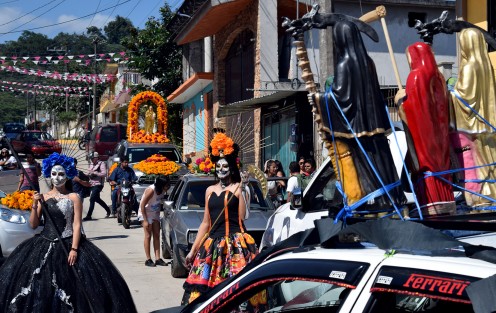 Jovencitas caracterizadas de la  santa muerte, automóviles adornados con flores e imágenes acompañan durante el recorrido del arco floral, que es cargado por los creyentes hasta la puerta del panteón de ese municipio, donde habrá de ser colocado.
