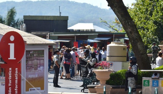 Un grupo de turistas tratan de encontrar lugares que visitar en la capital, mientras la Guardia Nacional resguarda el Palacio del Gobierno por la reunión de seguridad que realiza en este sitio.