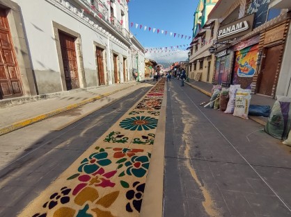 La alfombra artesanal se extiende por varias cuadras del Pueblo Mágico y es un atractivo. Esta obra es elaborada a mano cuidadosamente. Los colores resaltan las imágenes religiosas así como distintas figuras con flores y orquídeas.