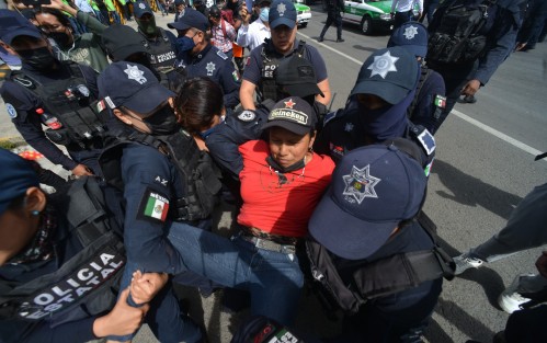Se informa que durante la detención, Arely N forcejeó y mordió a una oficial, además de patear la cámara de un reportero gráfico que cubría la manifestación. 