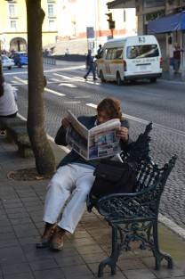 Leer un diario en una banca. Una persona lee el periódico en la céntrica calle de Enríquez, lo que cada vez es más raro debido a la tecnología de estos días.