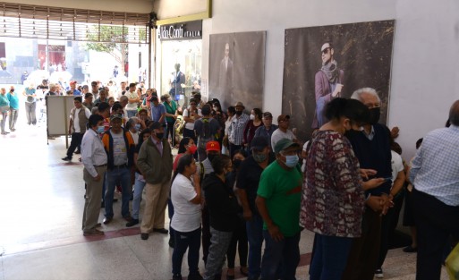 Adultos mayores en compañía de sus familiares acudieron a la sucursal del Banco del Bienestar ubicada en el Pasaje Tanos para cobrar su pensión en ventanilla, o el cajero ubicado.  La fila se extendía por la banqueta de Enríquez, lo que desagradó al administrador del edificio.  