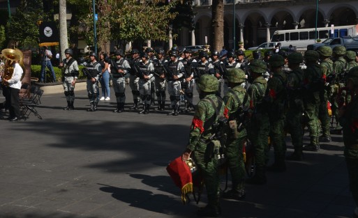Durante la guardia de honor de los lunes en el parque Juárez un niño y su familia saludan a la badera mientras los elementos de Sedena y Guardia Nacional hacen lo propio.
