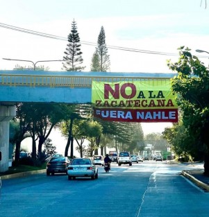 En el puente del tren sobre la avenida Lázaro Cárdenas, a la altura de Agua Santa, colgaron una lona con el mensaje No a la zacatecana. Fuera Nahle, contra la aspirante a la coordinación de la defensa de la 4T en Veracruz, Rocío Nahle.